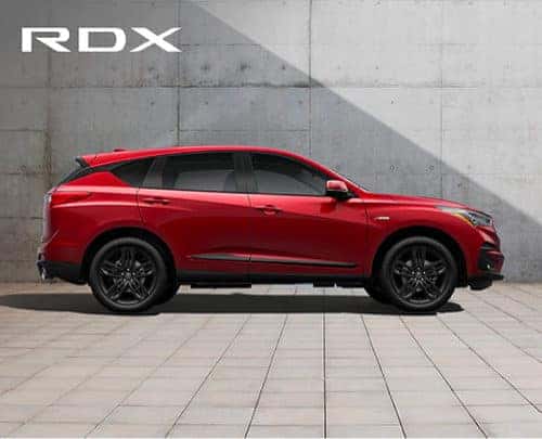 Side View of Red Acura RDX in front of a brick wall