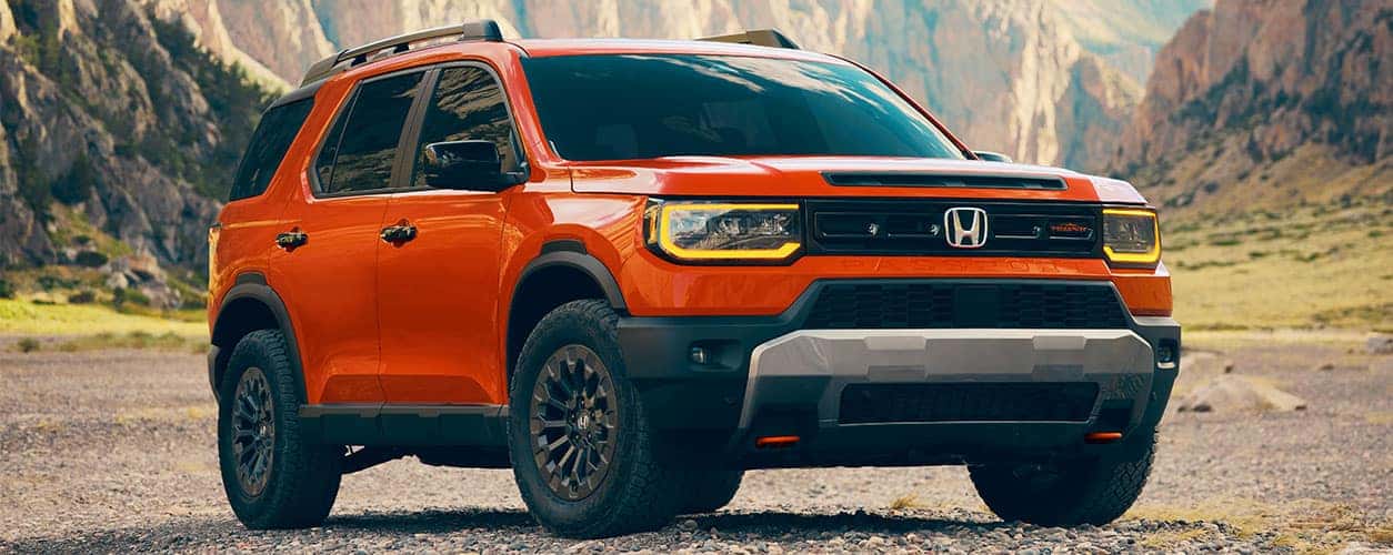 2026 Honda Passport TrailSport parked offroad in sunset orange