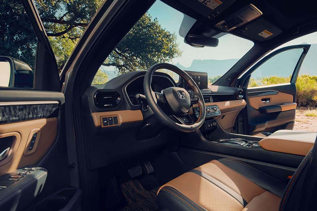 2026 Honda Passport TrailSport showing off front seats and infotainment technology with leather seats and doors opened