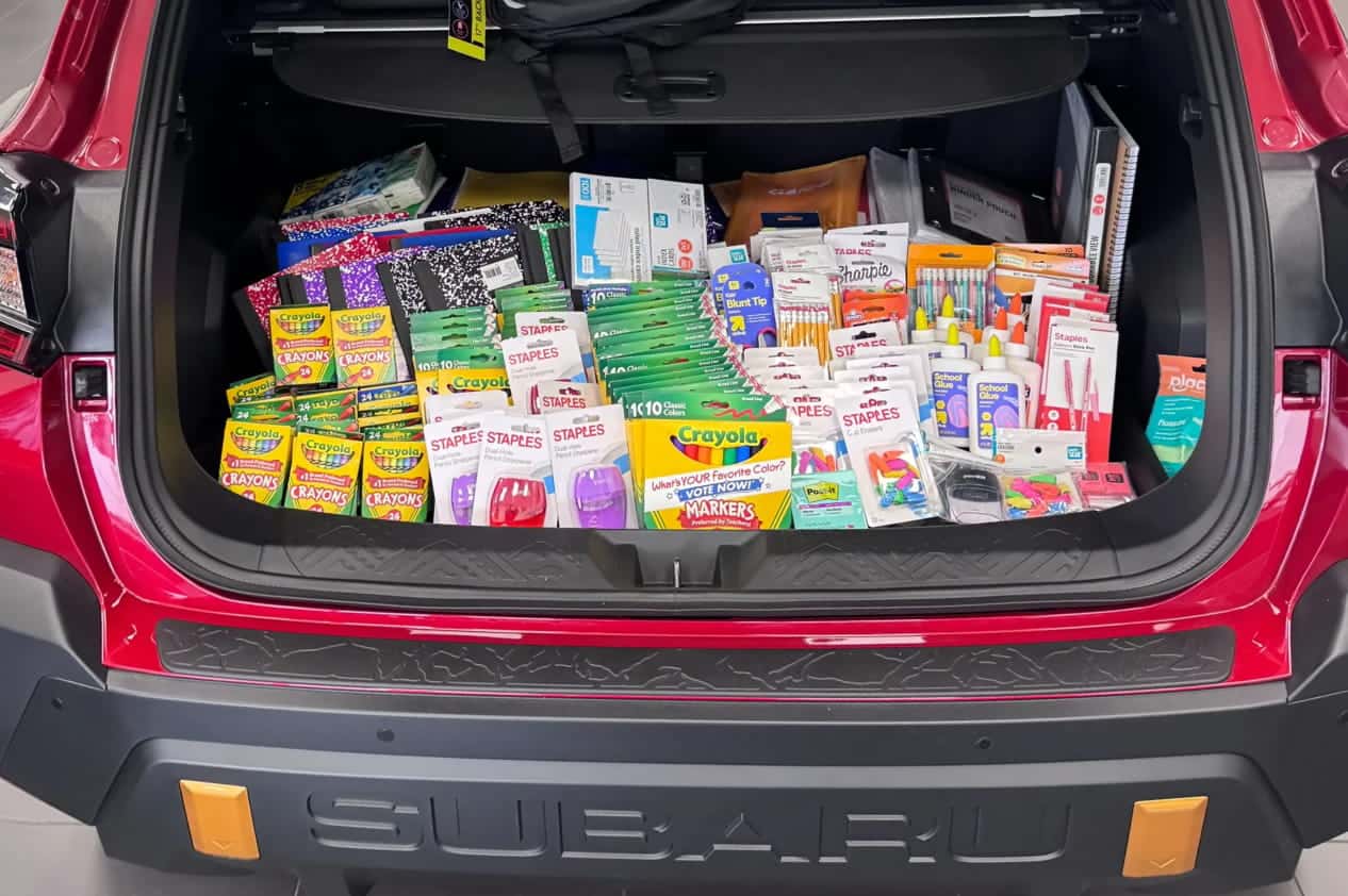School supplies filling the cargo area of a red vehicle.