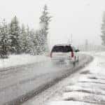 SUV white driving in snow storm