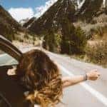 woman sticking her head out of a car