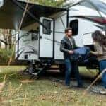 man and woman camping with a trailer rv