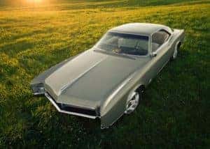1967 Buick Riviera in a grass field