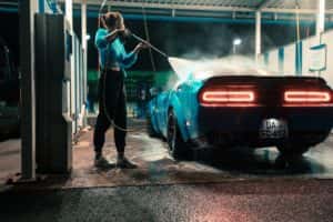 Woman wearing blue washing her blue car