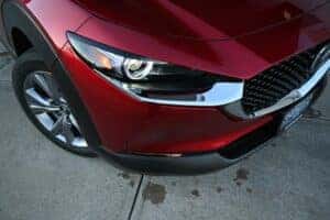 up close angle of the right headlight of a red Mazda