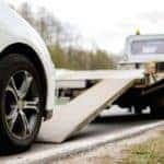 Loading broken car on a tow truck on a roadside