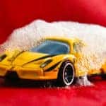 small toy car being washed with bubbles like a full-sized car