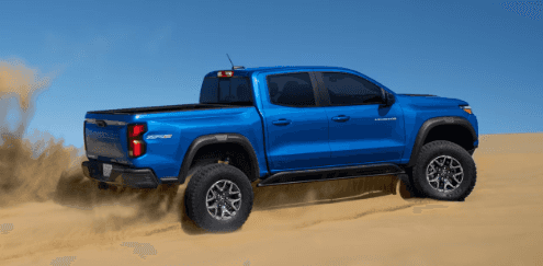 2024 Chevy Colorado in blue paint off-roading on sand dunes.