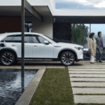 electric car parked by large modern home