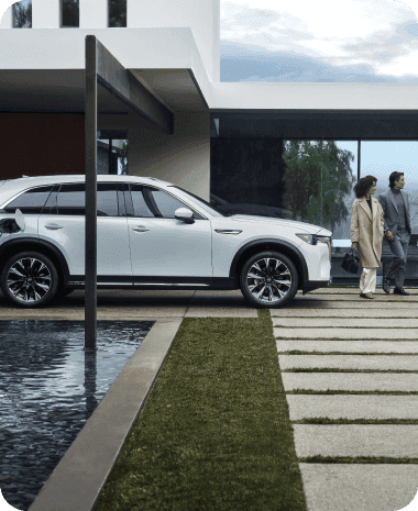 electric car parked by large modern home