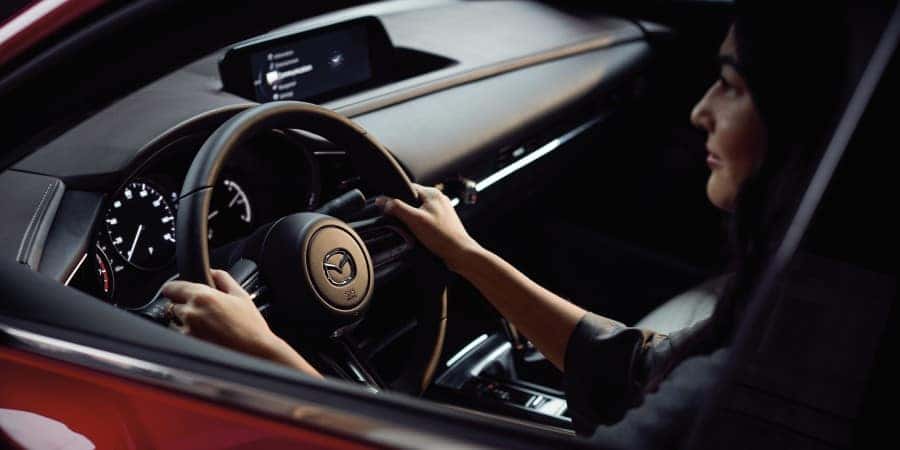 A woman driving a red 2020 Mazda CX-30 - El Dorado Mazda in McKinney, Texas
