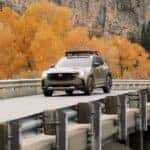Mazda CX-50 driving across a bridge in the autumn