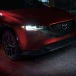 Close up on front of a Mazda CX-5 with its headlights on at night