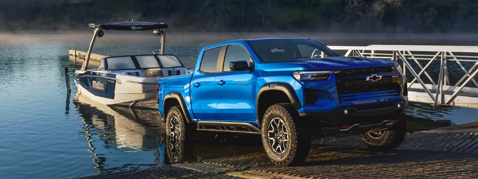 Front exterior view of a 2026 Chevrolet Colorado backing into a body of water to release a boat