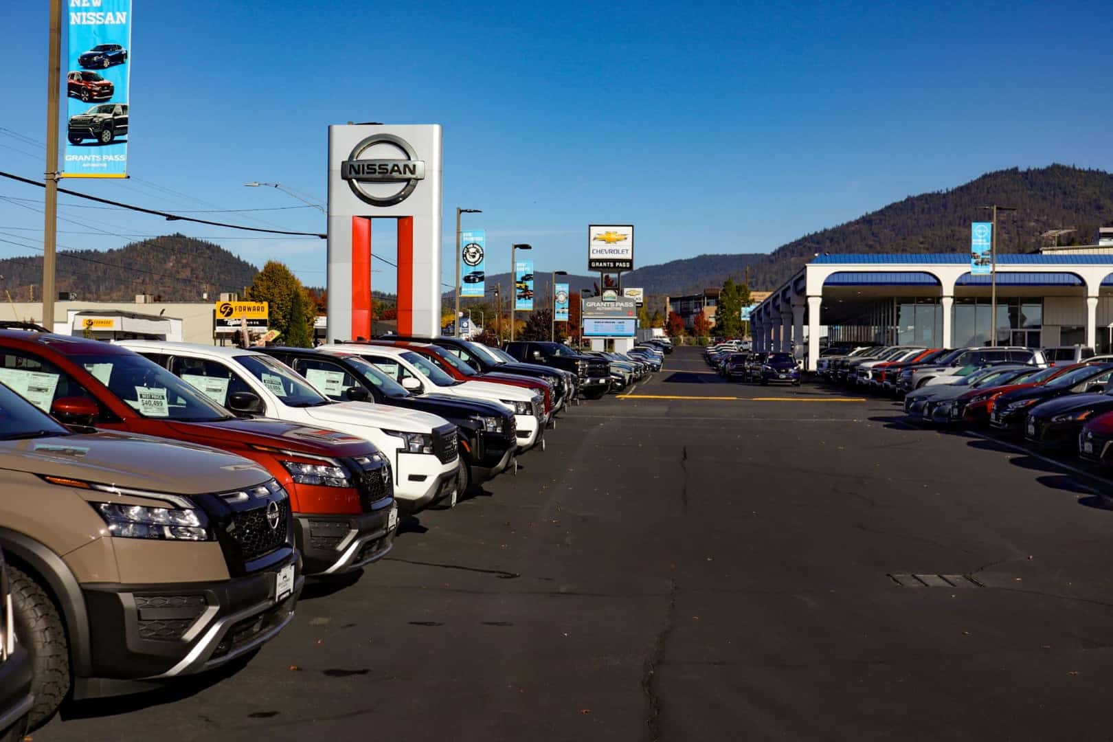 Row of used and new Nissan Rogue's, SUV's and Altima Sedans at Grants Pass Nissan