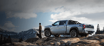 2026 Nissan Frontier parked on a rocky ridge overlooking mountain peaks