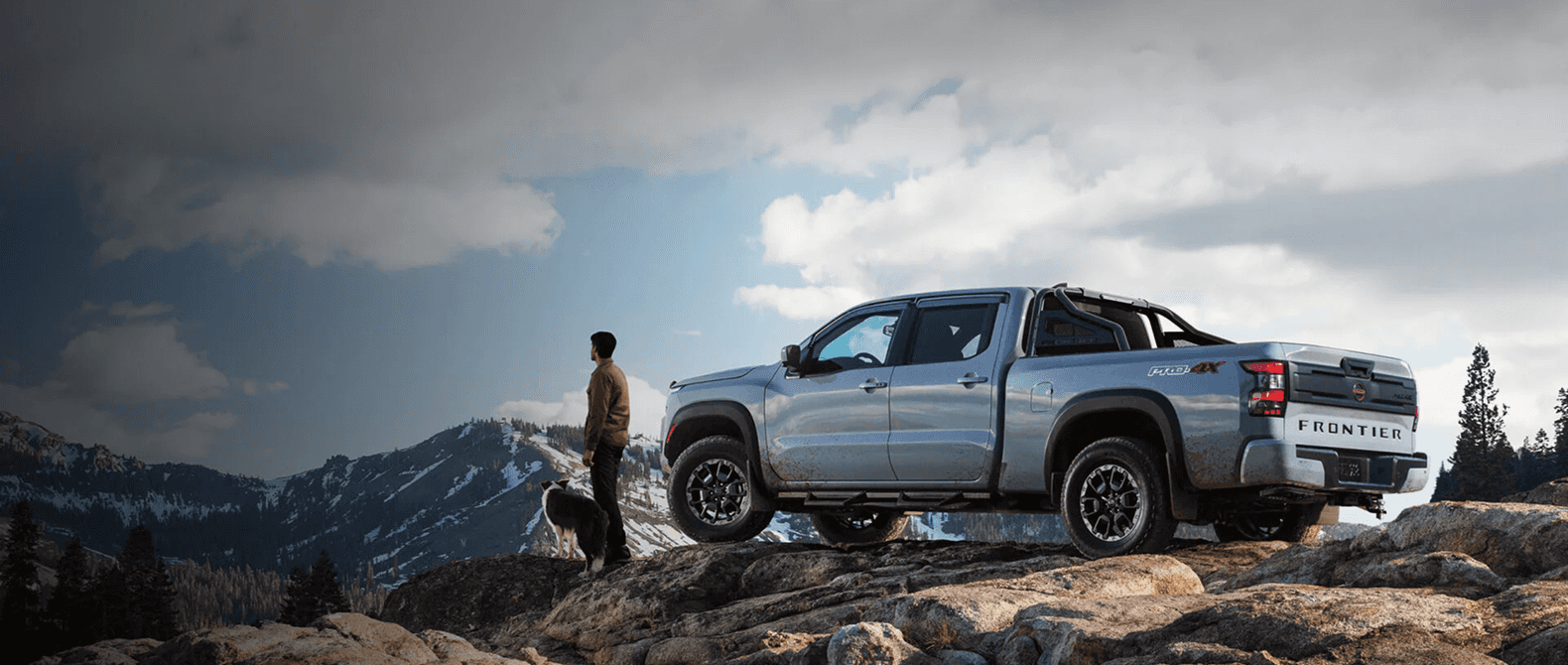 2026 Nissan Frontier parked on a rocky ridge overlooking mountain peaks