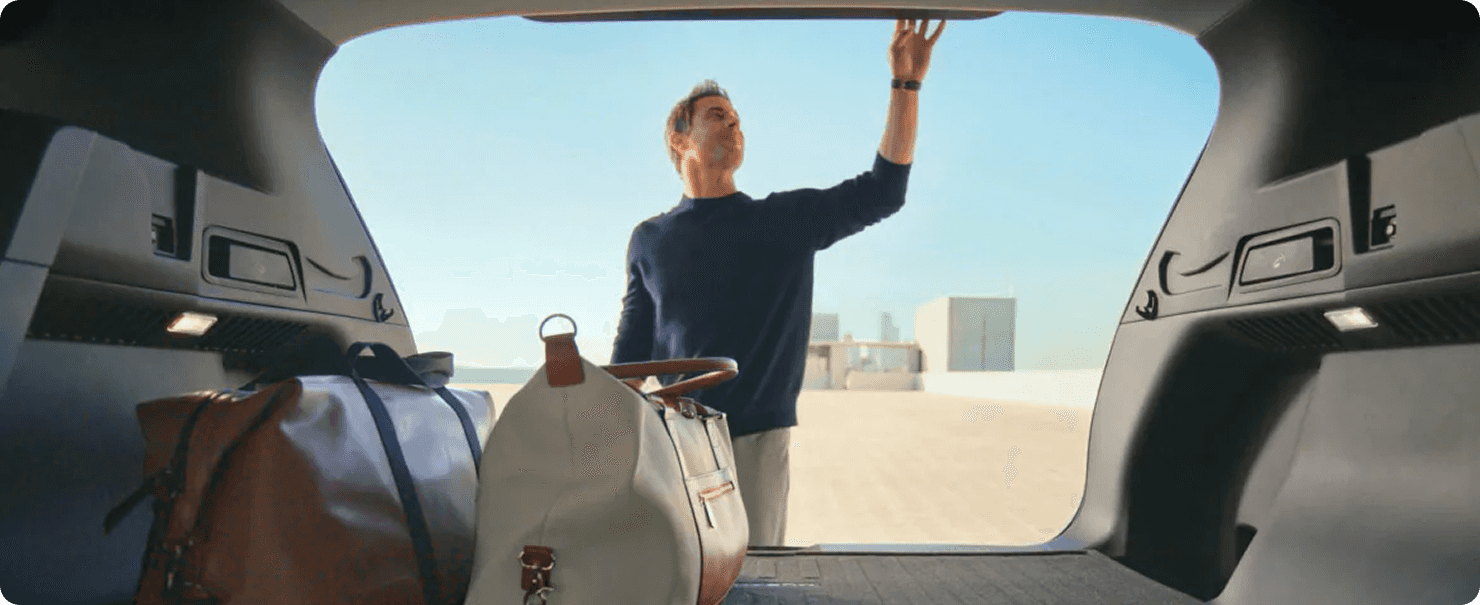 Man loading luggage into the Murano rear cargo area through the open liftgate