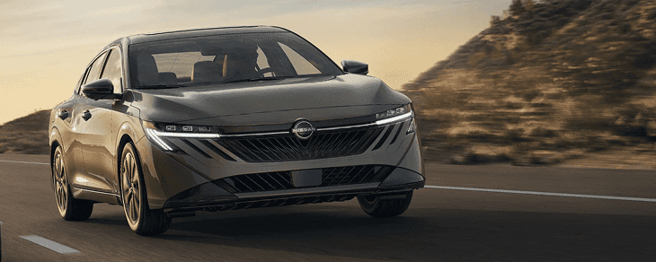Front view of a champagne Sentra driving on a desert highway