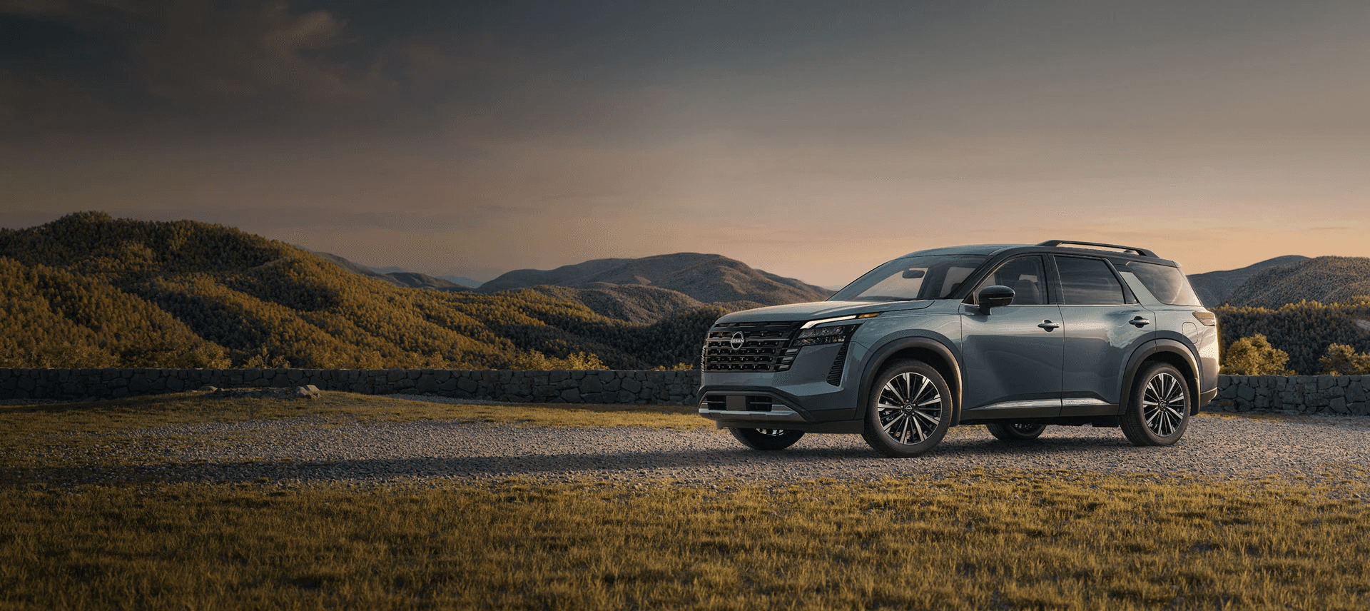 2026 Nissan Pathfinder parked on a gravel ridge with rolling hills at dusk