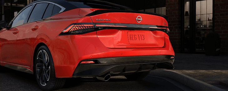 Close-up of red Sentra rear bumper, badge, and exhaust