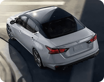 Rear angle of silver Nissan Altima on curved road