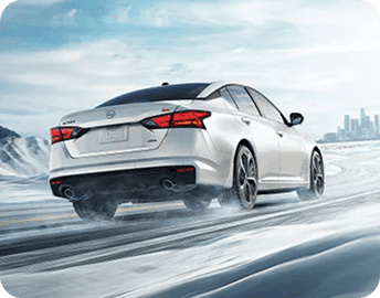 Rear view of Nissan Altima driving on snowy road