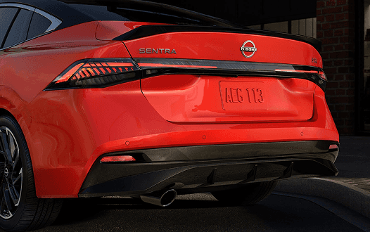 Close-up of red Sentra rear with illuminated tail lights and SENTRA badge