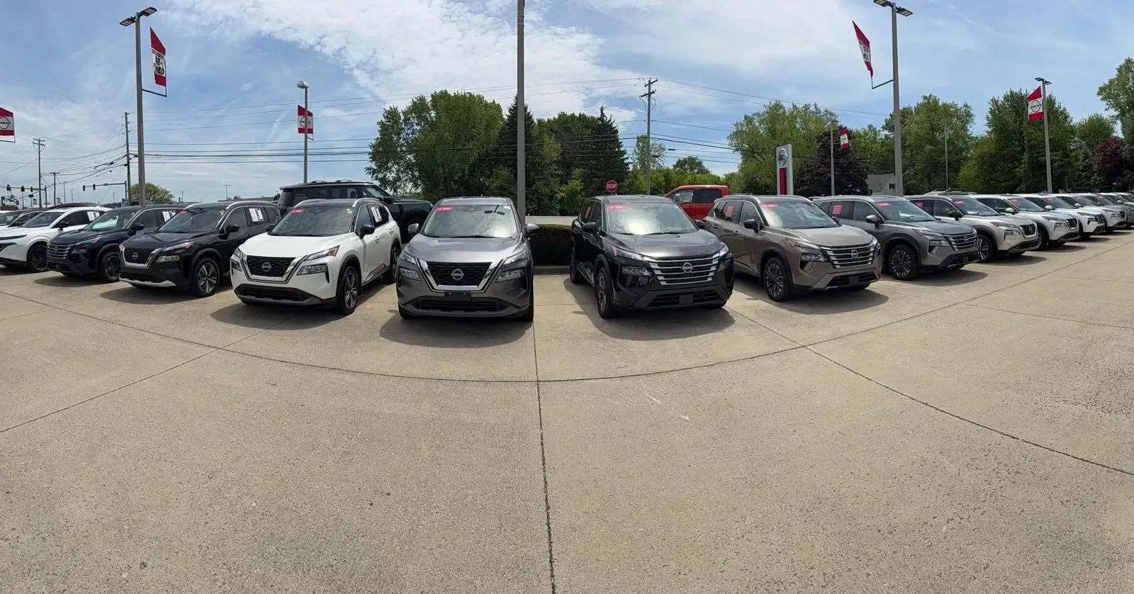 A row of Certified Pre-Owned Nissan Rogue and Sentra models on the I-90 Nissan lot in Sheffield Village, Ohio