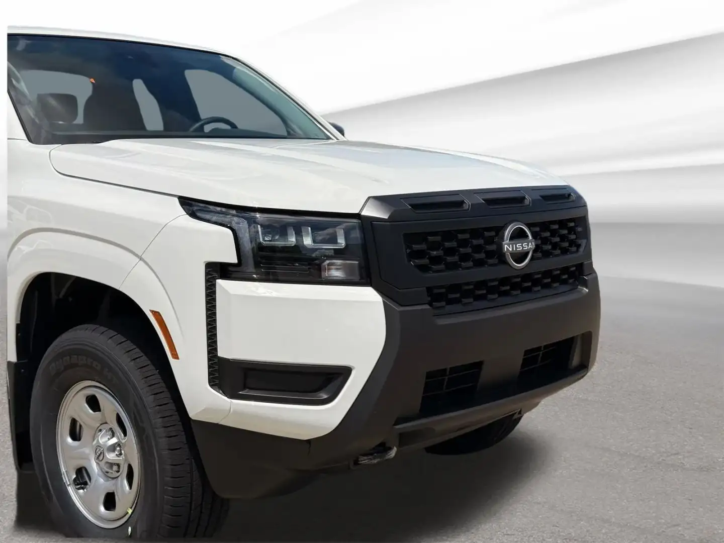 Front three-quarter view of a white 2026 Nissan Frontier at I-90 Nissan, Sheffield Village, Ohio