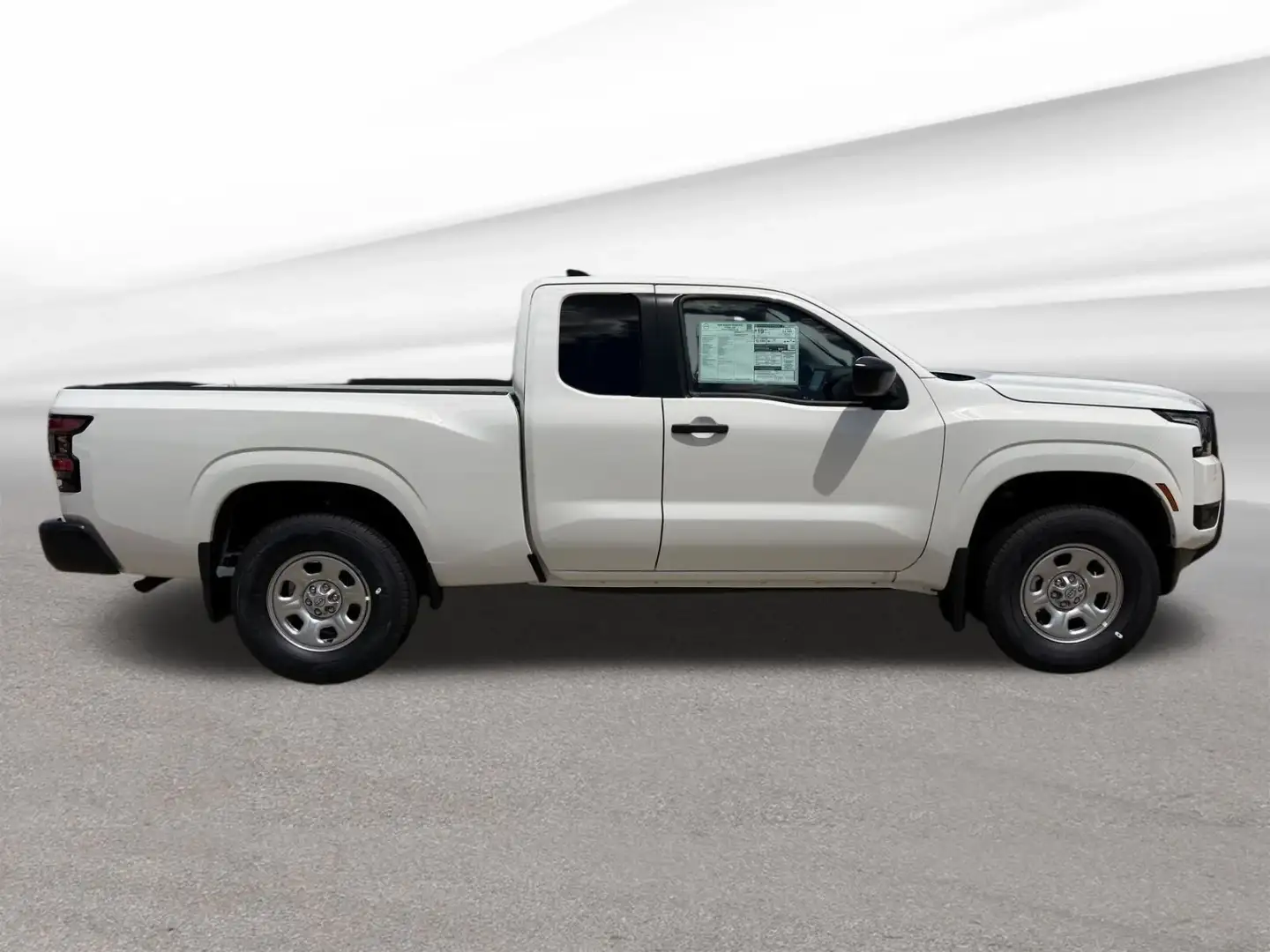Full driver-side profile of a 2026 Nissan Frontier King Cab with the window sticker visible
