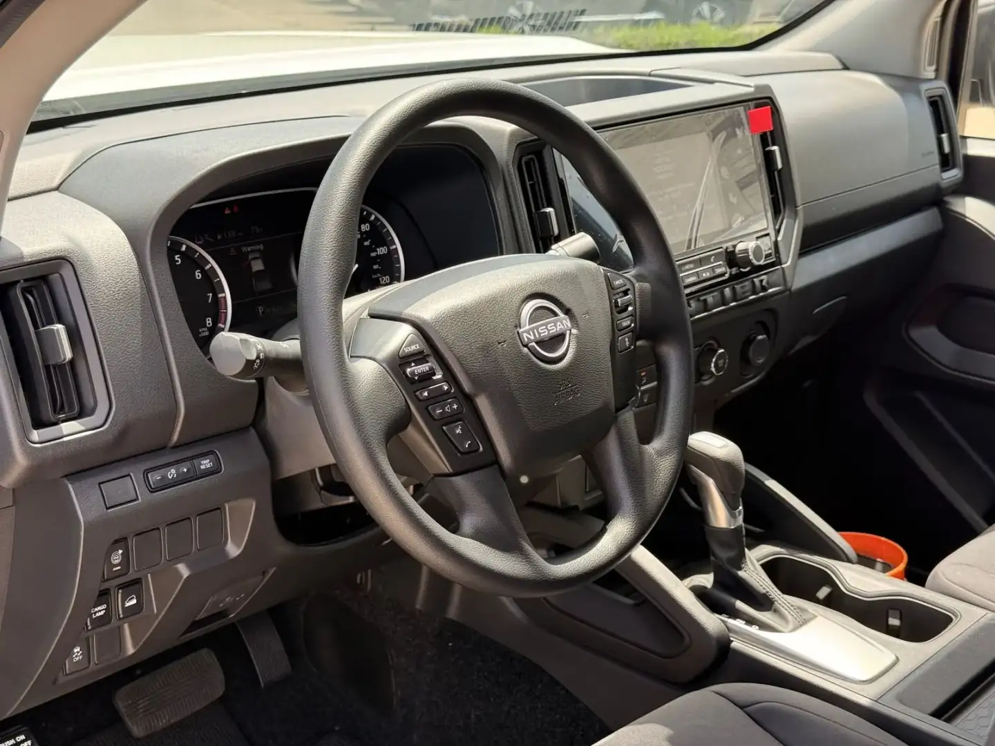 Interior of the 2026 Nissan Frontier showing the dashboard, steering wheel and touchscreen