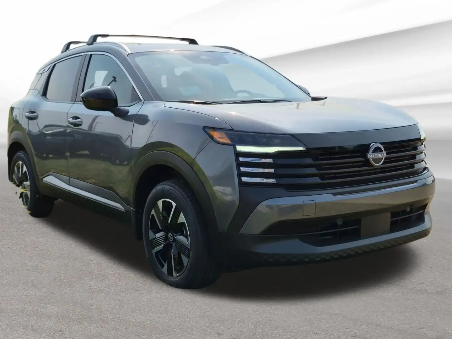 Nissan Kicks in gunmetal gray, front three-quarter view on the lot at I-90 Nissan
