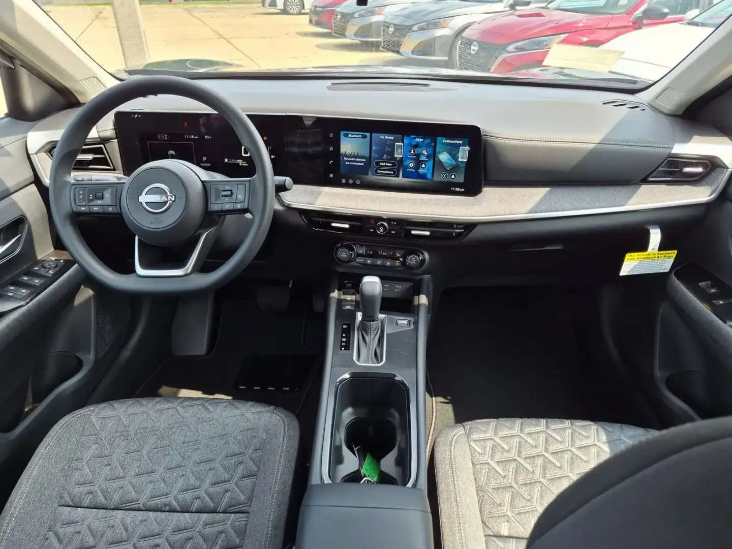 Nissan Kicks cabin, showing the steering wheel, dual screens and center console