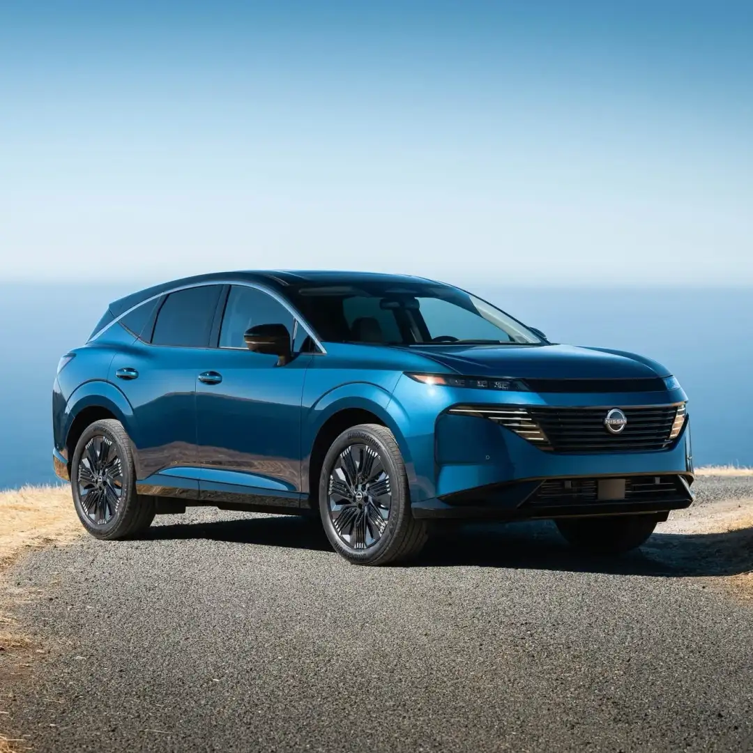 Nissan Murano in blue, front three-quarter view, on a coastal road