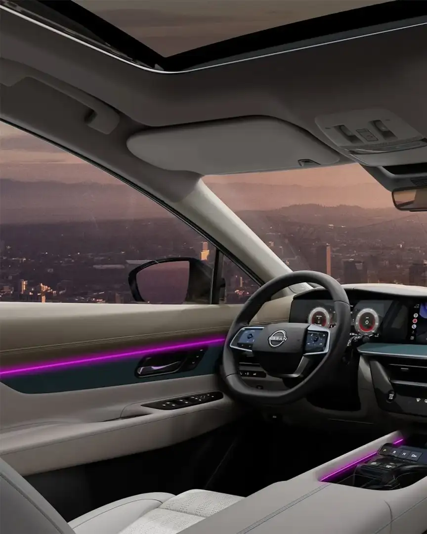 Interior of the Nissan Murano at dusk showing the ambient lighting strip and the view over a city