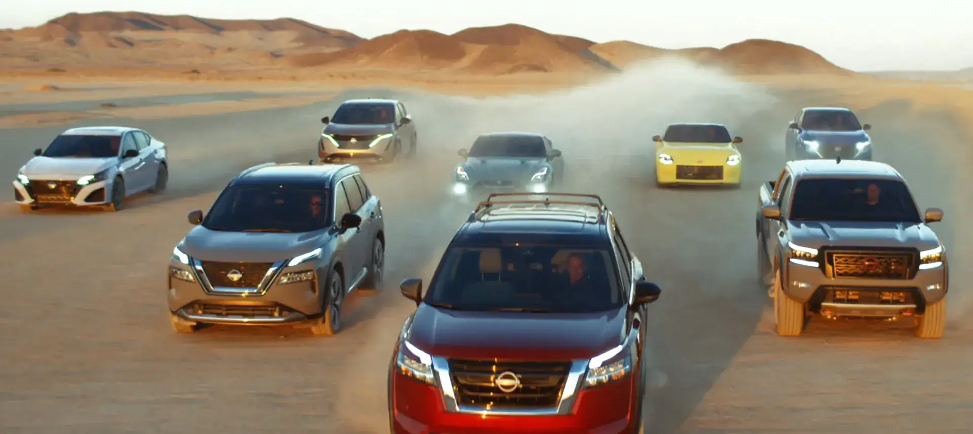 Nissan vehicles driving together across a desert landscape