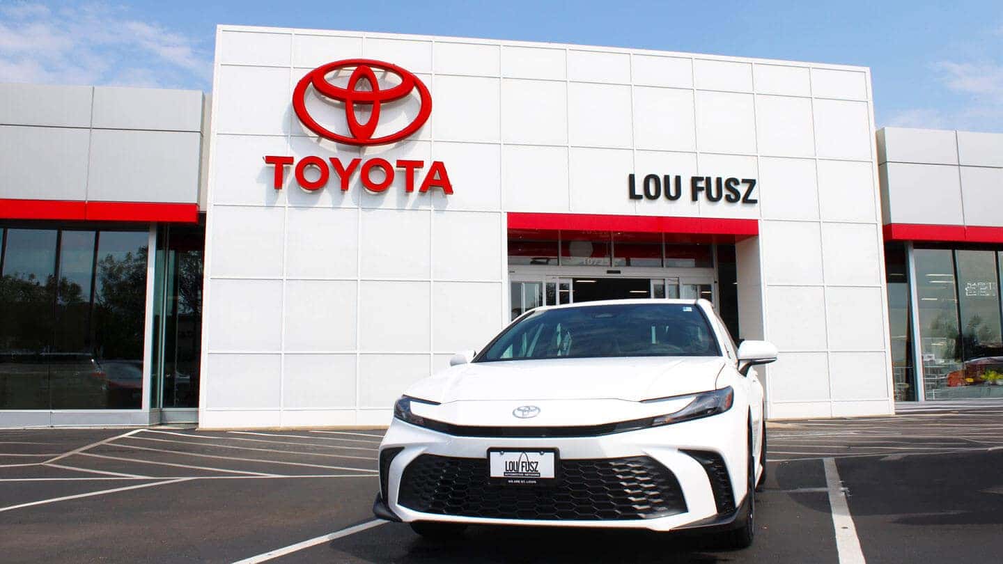 White 2025 Toyota Camry siting in front of Lou Fusz Toyota