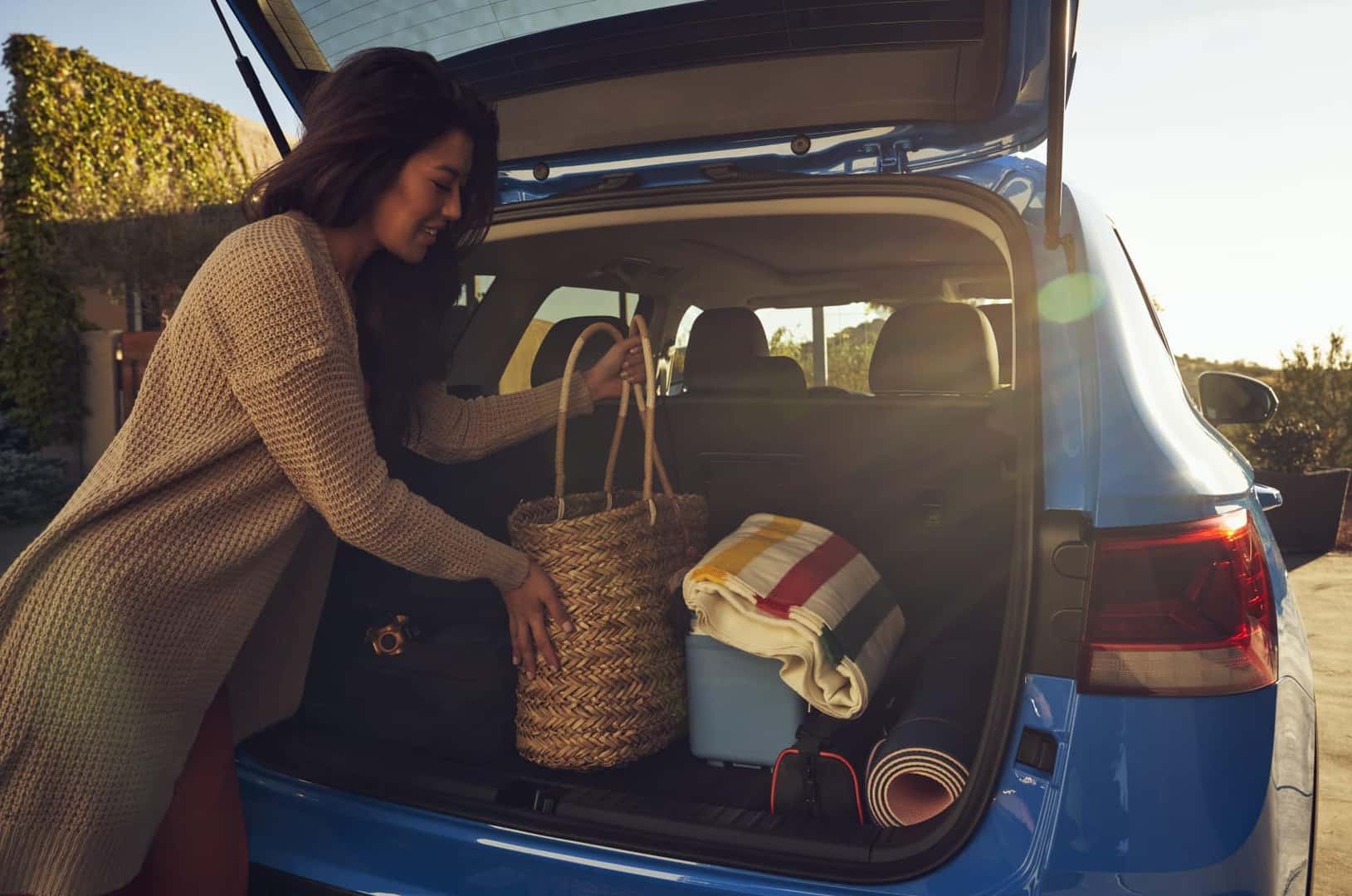 2022 Volkswagen Taos blue cargo area rear hatch up woman packing bags
