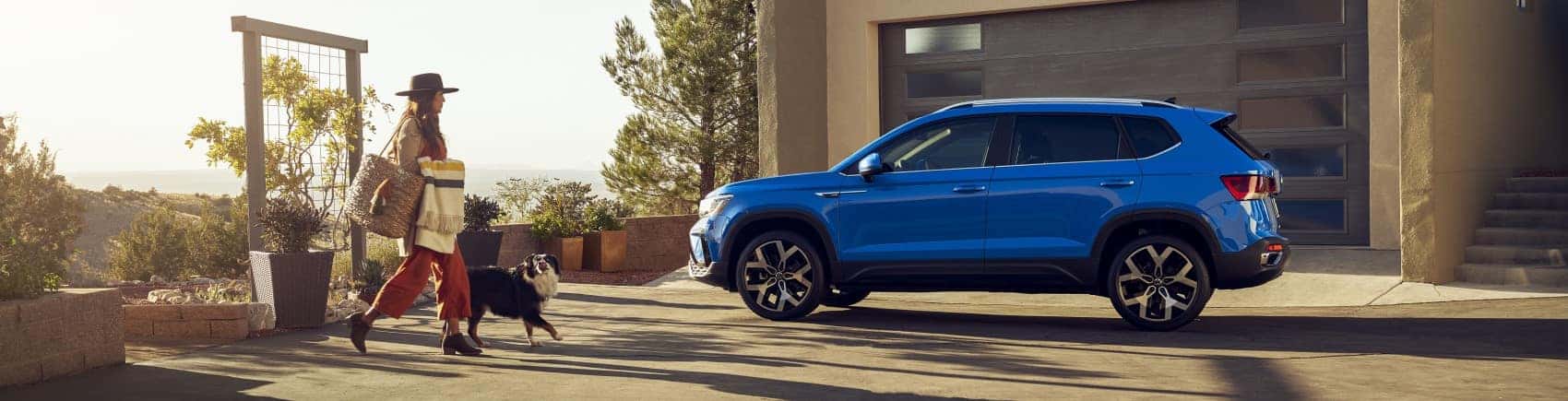 2022 Volkswagen Taos blue profile shot parked in driveway banner