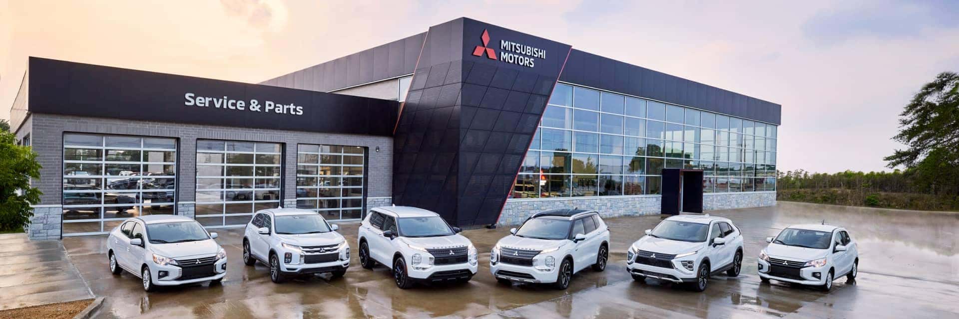 Full Mitsubishi lineup in front of a general Mitsubishi dealership