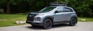 2025 Outlander Sport Trail Edition parked by grass