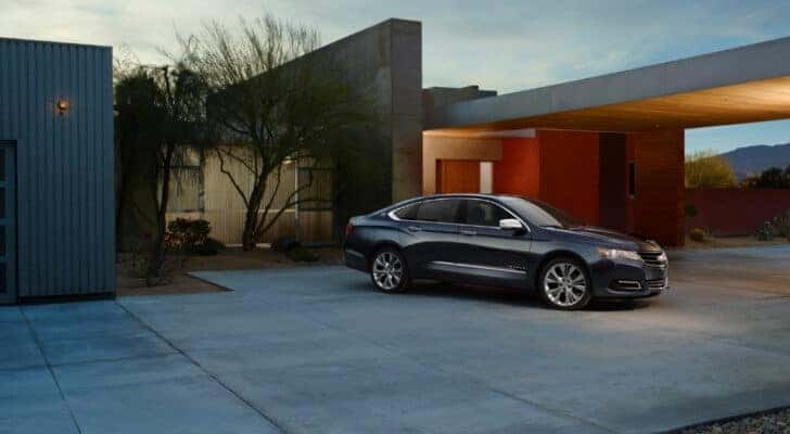 A dark blue 2014 Chevy Impala is shown parked on a driveway.