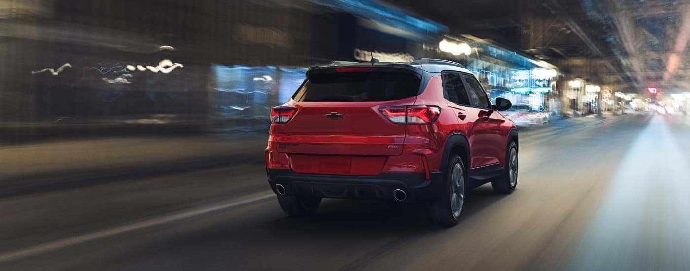 A red 2021 Chevy Trailblazer RS is shown driving to a used car dealer.