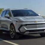 A grey 2025 Chevy Equinox EV for sale driving and angled right.