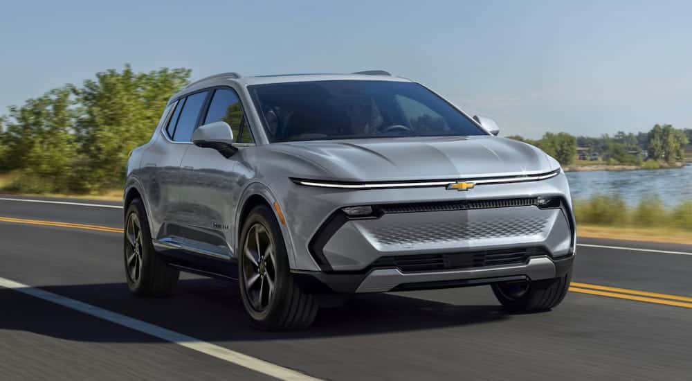A grey 2025 Chevy Equinox EV for sale driving and angled right.