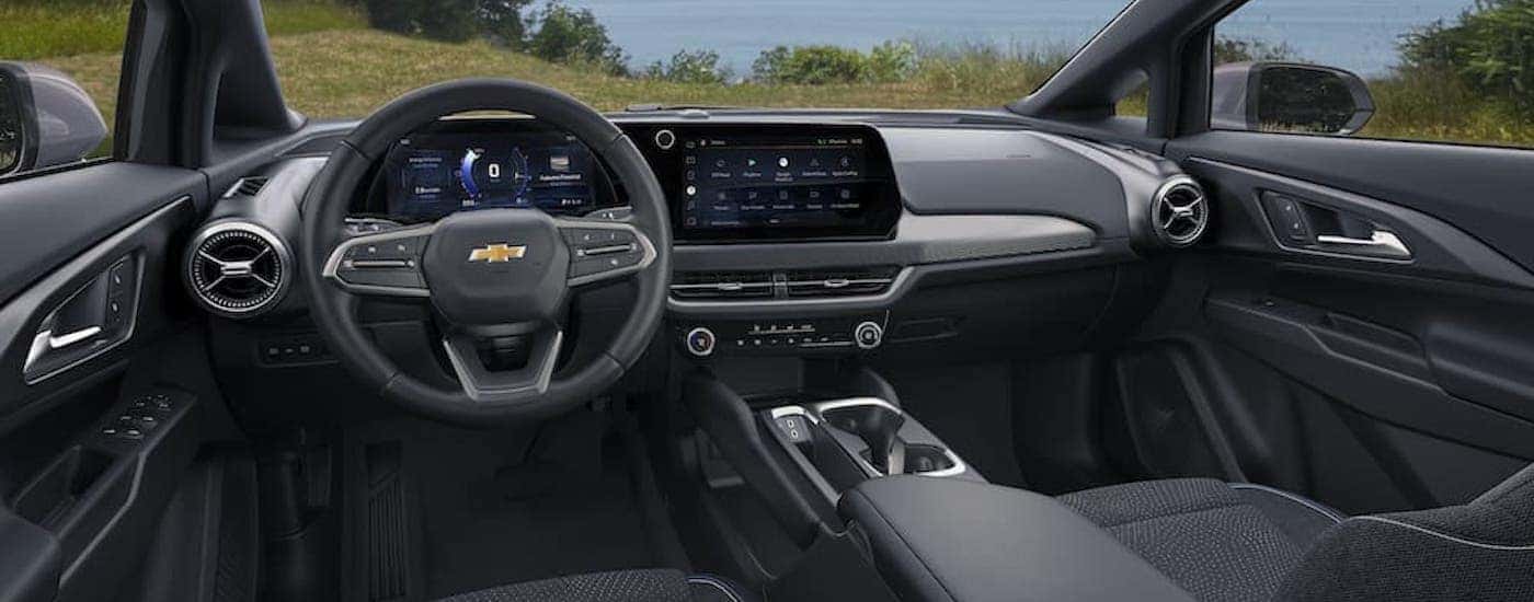 The black interior of a 2024 Chevy Equinox EV is shown from the drivers seat.