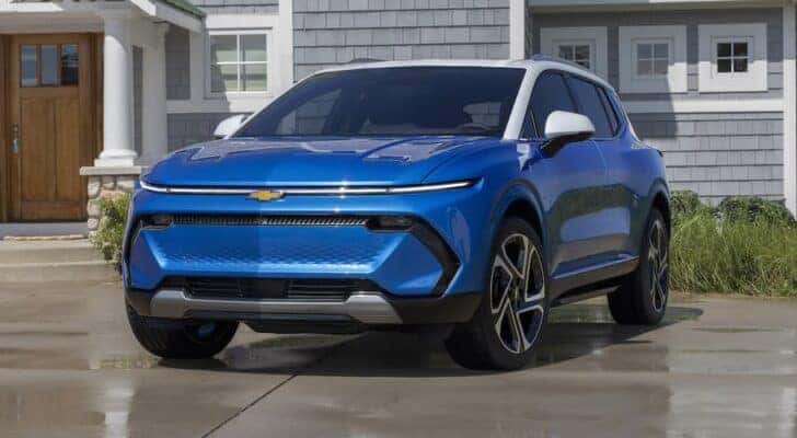 A blue 2024 Chevy Equinox EV for sale parked on a driveway.