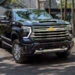A black 2025 Chevy Silverado 2500 High Country parked in a driveway.